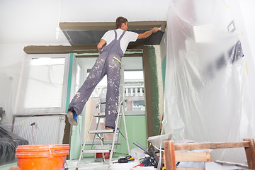 Image showing Plasterer renovating indoor walls and ceilings.