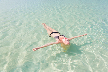 Image showing Caucasian lady floating in turquoise sea.