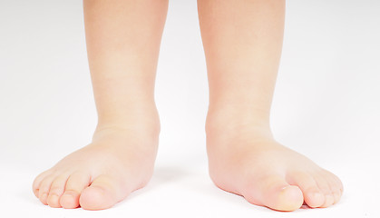 Image showing Little person standing up barefoot towards bright background
