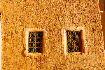 Image showing   yellow window in construction and brown wall  