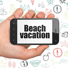 Image showing Tourism concept: Hand Holding Smartphone with Beach Vacation on display