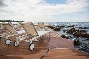 Image showing loungers on the rocky beach