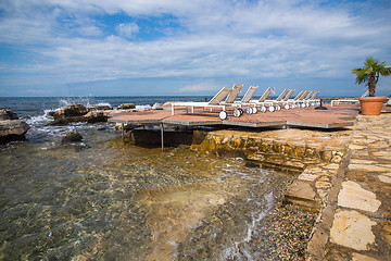 Image showing loungers on the rocky beach