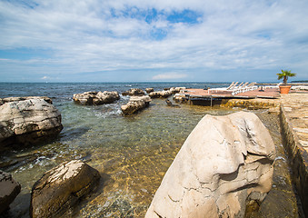 Image showing loungers on the rocky beach