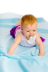 Image showing baby girl with a pacifier crying. Studio