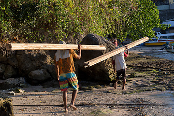 Image showing Men transports cargo from ship to shipyard