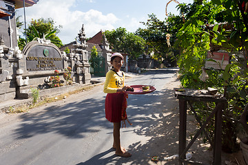 Image showing indonesian girl bring offerings to the home temple