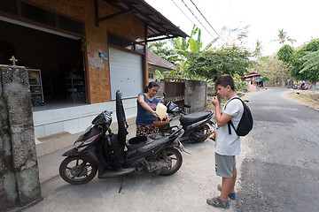 Image showing Woman sell benzine in plastic bottle