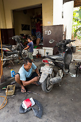 Image showing Service man repair deflated damaged tyre