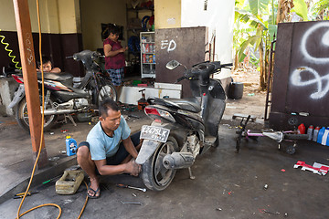 Image showing Service man repair deflated damaged tyre