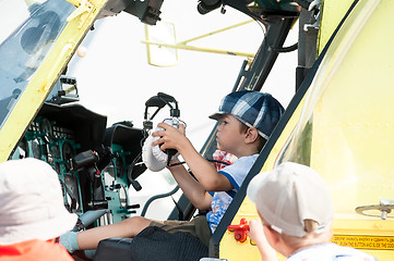 Image showing Little boy sitting in cabin of the MI-8 helicopter