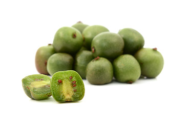 Image showing Kiwi berry sliced open in front of pile of berries