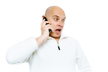 Image showing Bald man emotionally communicates by phone. Isolated. Studio