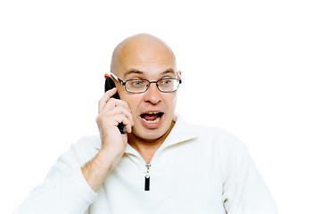 Image showing Bald man emotionally communicates by phone. Isolated. Studio