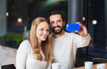 Image showing happy couple with tablet pc and coffee at cafe