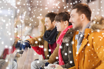 Image showing happy friends watching hockey game on skating rink