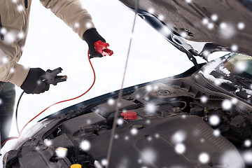 Image showing closeup of man under bonnet with starter cables