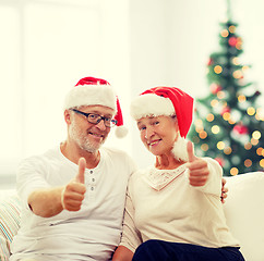 Image showing happy senior couple in santa helper hats