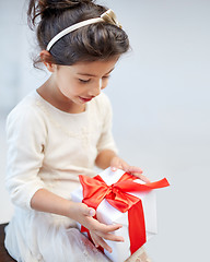 Image showing happy little girl with gift box at home