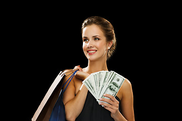 Image showing smiling woman in dress with shopping bags