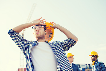 Image showing group of builders in hardhats outdoors