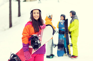 Image showing happy friends in helmets with snowboards