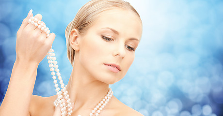 Image showing beautiful woman with sea pearl necklace over blue