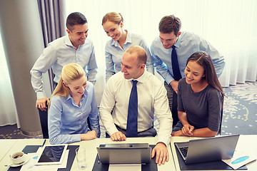 Image showing smiling business people with laptop in office