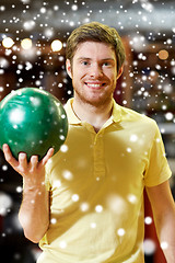 Image showing happy young man holding ball in bowling club