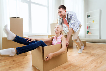 Image showing couple with cardboard boxes having fun at new home