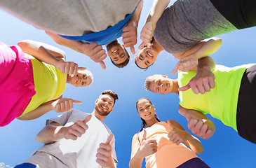 Image showing group of happy sporty friends showing thumbs up