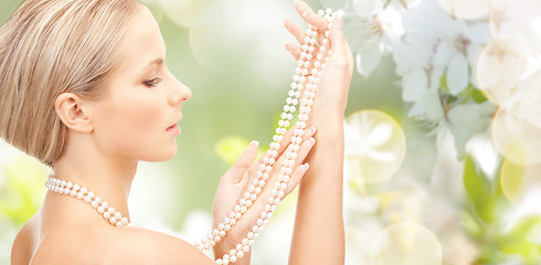 Image showing woman with pearl necklace over cherry blossom