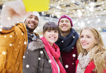 Image showing happy friends with smartphone on skating rink