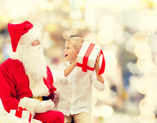 Image showing smiling little boy with santa claus and gifts