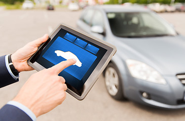 Image showing close up of male hands with car icon on tablet pc