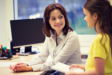 Image showing school girl with notebook and teacher in classroom