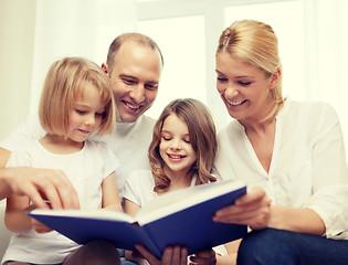 Image showing smiling family and two little girls with book