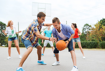 Image showing group of happy teenagers playing basketball