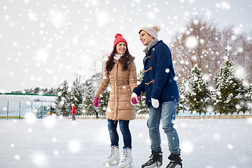 Image showing happy couple ice skating on rink outdoors