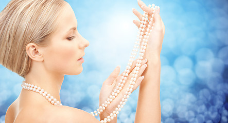 Image showing beautiful woman with sea pearl necklace over blue