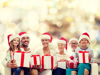 Image showing happy family in santa helper hats with gift boxes