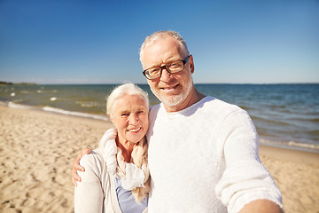 Image showing seniors taking picture with selfie stick on beach