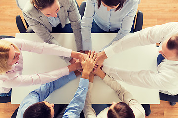 Image showing close up of business team with hands on top