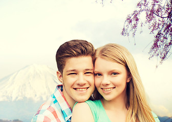 Image showing smiling couple hugging over mountains background