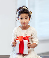 Image showing happy little girl with gift box at home