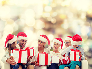 Image showing happy family in santa helper hats with gift boxes