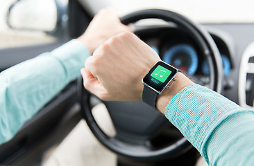 Image showing hands with music icon on smartwatch driving car
