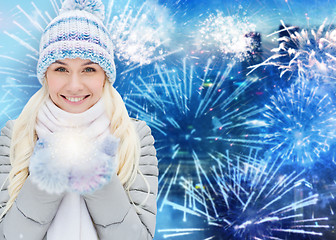 Image showing happy young woman in winter clothes over firework