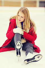 Image showing young woman fell down on skating rink