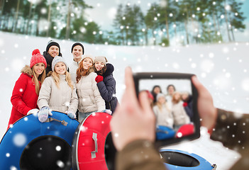 Image showing group of smiling friends with snow tubes